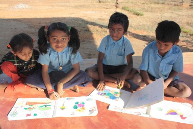 Children learning about the environment through the active story-based technique, doodling images they heard about in the story.