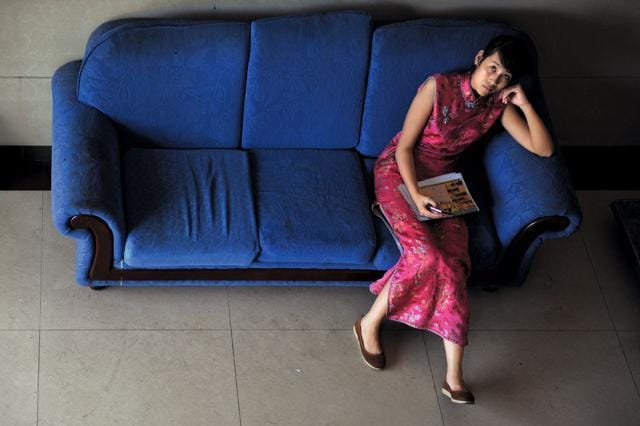 After peak business hours, the receptionist of a restaurant in Dongxing, a city in China on the Vietnamese border, whiles away the time playing with a cellphone. (Matthias Messmer) After peak business hours, the receptionist of a restaurant in Dongxing, a city in China on the Vietnamese border, whiles away the time playing with a cellphone. (Matthias Messmer)