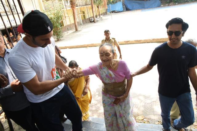 Varun Dhawan helps an old lady climb the stairs. Varun Dhawan helps an old lady climb the stairs.