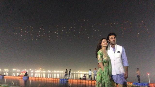 Ranbir Kapoor and Alia Bhatt at Sangam with drones displaying the name of their upcoming movie in the sky behind them in Kumbh Mela, in Prayagraj. (HT Photo) Ranbir Kapoor and Alia Bhatt at Sangam with drones displaying the name of their upcoming movie in the sky behind them in Kumbh Mela, in Prayagraj. (HT Photo)