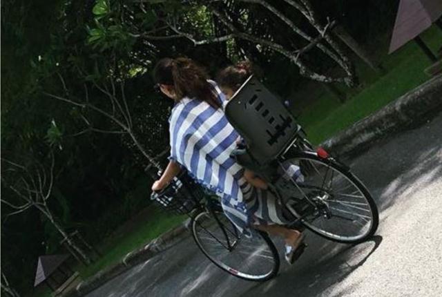Mira and Misha riding a bike in Phuket.
