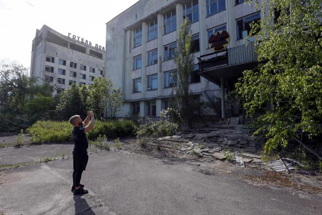 A visitor takes photos of a building in the abandoned city of Pripyat, near the Chernobyl nuclear power plant, Ukraine June 2, 2019. (REUTERS) A visitor takes photos of a building in the abandoned city of Pripyat, near the Chernobyl nuclear power plant, Ukraine June 2, 2019. (REUTERS)