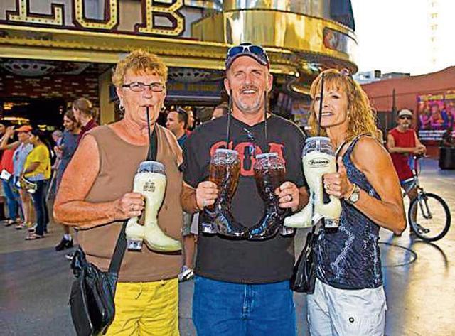 People drink from giant novelty glasses. Vegas likes to keep its visitors tipsy so they’ll spend more when they gamble. (GETTY IMAGES) People drink from giant novelty glasses. Vegas likes to keep its visitors tipsy so they’ll spend more when they gamble. (GETTY IMAGES)