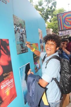 An attendee writes on the movie poster wall of Kashish