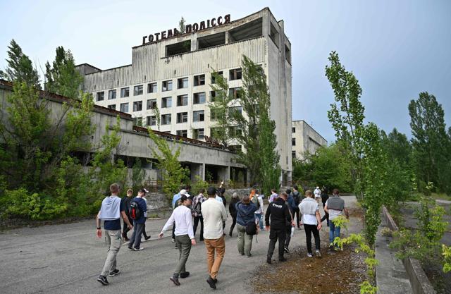 Visitors walk in the ghost city of Pripyat during a tour in the Chernobyl exclusion zone on June 7, 2019. (AFP) Visitors walk in the ghost city of Pripyat during a tour in the Chernobyl exclusion zone on June 7, 2019. (AFP)
