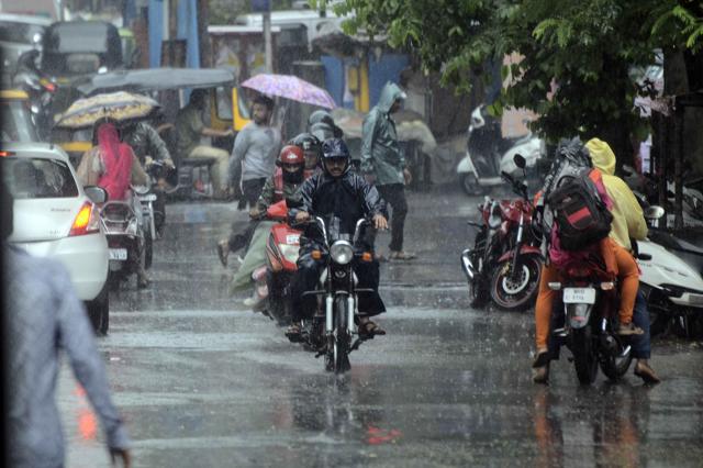 With monsoon greeting the city on Monday, residents were seen using umbrellas and raincoats to prevent themselves from getting drenched. (Ravindra Joshi/HT PHOTO) With monsoon greeting the city on Monday, residents were seen using umbrellas and raincoats to prevent themselves from getting drenched. (Ravindra Joshi/HT PHOTO)
