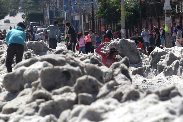 People are seen on the street after the hail storm. (AFP) People are seen on the street after the hail storm. (AFP)