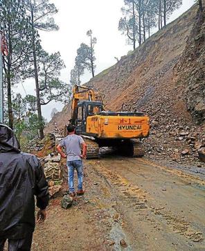 Workers clear a road in Uttarkashi after rains. (HT Photo ) Workers clear a road in Uttarkashi after rains. (HT Photo )