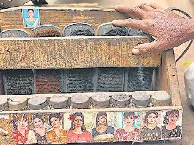 Ram Sevak’s shoeshine box is stacked with five shoe brushes, while its lower shelf houses various types of shoe polishes. (HT Photo)