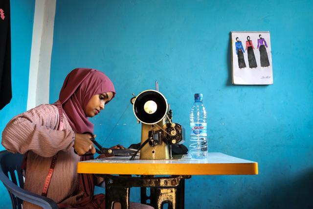 (FILES) In this file photograph taken on November 3, 2018, Hawa Adan Hassan, 23 year-old, university student, uses a sewing machine at her home in Mogadishu, Somalia. (Photo by Abdi HAJJI HUSSEIN / AFP) (AFP) (FILES) In this file photograph taken on November 3, 2018, Hawa Adan Hassan, 23 year-old, university student, uses a sewing machine at her home in Mogadishu, Somalia. (Photo by Abdi HAJJI HUSSEIN / AFP) (AFP)