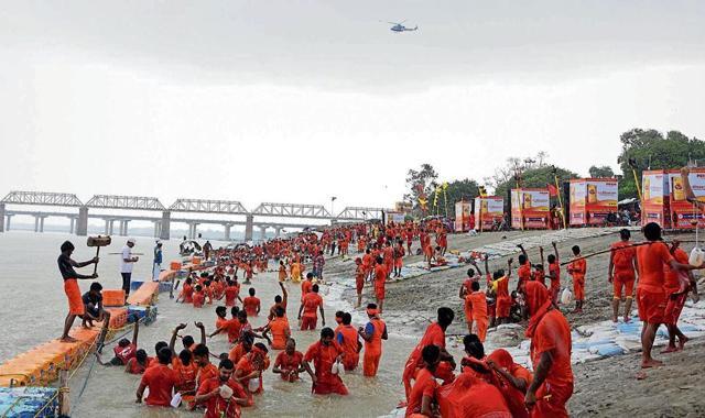 Clad in saffron and carrying kanwars, these Shiva devotees cover long distances barefoot. (HT Photo ) Clad in saffron and carrying kanwars, these Shiva devotees cover long distances barefoot. (HT Photo )