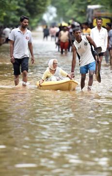 A senior citizen being carried in a boat in Sangli on Friday. (Pratham Gokhale/HT Photo)