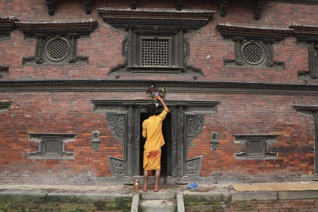 A Nepalese priest displays a machine made painting above the door of a temple during Naag Panchami festival in Bhaktapur, Nepal. (AP) A Nepalese priest displays a machine made painting above the door of a temple during Naag Panchami festival in Bhaktapur, Nepal. (AP)