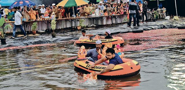 Residents immerse idols in the artificial pond set up by businessman Vijay Aswani and his family at Vaibhavnagar in Pimpri on Thursday. (HT/PHOTO)