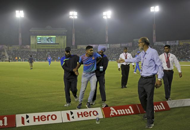 Security officials restrain a man after he tried to run towards the pitch. (AP) Security officials restrain a man after he tried to run towards the pitch. (AP)