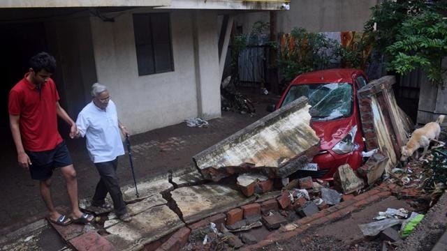 Residents walk past a damaged car after a wall collapsed following heavy rains in Pune, September 26, 2019. (Reuters) Residents walk past a damaged car after a wall collapsed following heavy rains in Pune, September 26, 2019. (Reuters)
