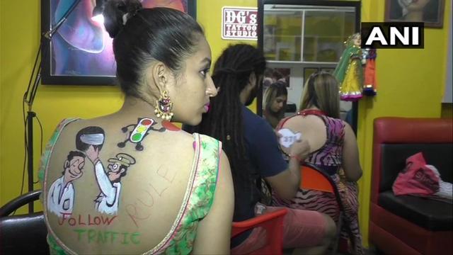 Woman in Surat getting Navratri special 2019 tattoo. (Twitter/ANI) Woman in Surat getting Navratri special 2019 tattoo. (Twitter/ANI)