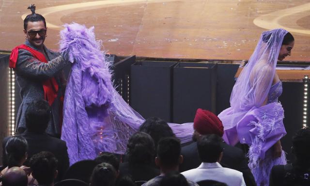 Bollywood actor Ranveer Singh, left, walks along with his wife Deepika Padukone during the 20th International Indian Film Academy (IIFA) awards ceremony. (AP)