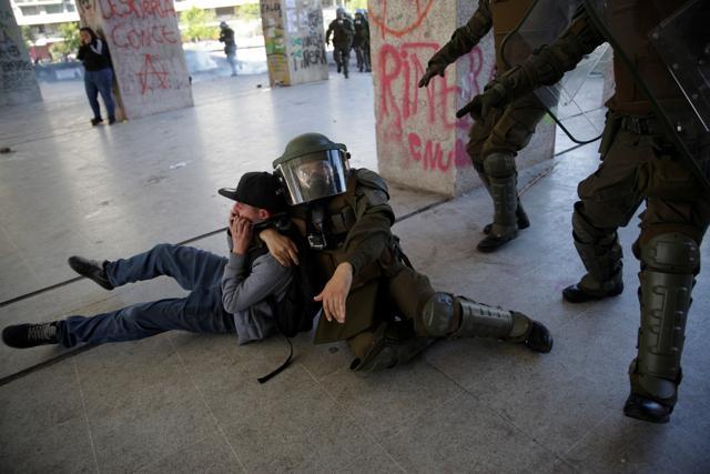 Officers of the Chilean police (Carabineros) detain a demonstrator during protests against Chile's government in Concepcion, Chile. (REUTERS) Officers of the Chilean police (Carabineros) detain a demonstrator during protests against Chile's government in Concepcion, Chile. (REUTERS)