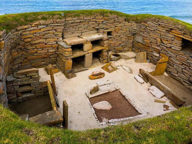 The central hearth with the dresser and sleeping spaces along the walls at the Skara Brae settlement. The central hearth with the dresser and sleeping spaces along the walls at the Skara Brae settlement.