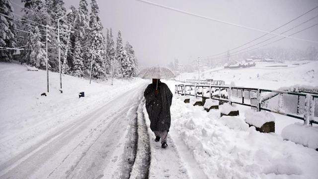 A man walks on a snow-covered road during the first snowfall of the season in Gulmarg on Wednesday. (ANI Photo) A man walks on a snow-covered road during the first snowfall of the season in Gulmarg on Wednesday. (ANI Photo)