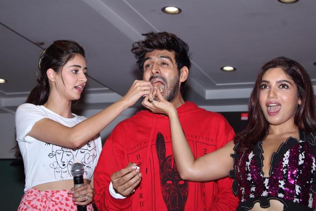 Ananya Panday and Bhumi Pednekar feed some cake to Kartik Aaryan at his cake-cutting ceremony. (Varinder Chawla ) Ananya Panday and Bhumi Pednekar feed some cake to Kartik Aaryan at his cake-cutting ceremony. (Varinder Chawla )