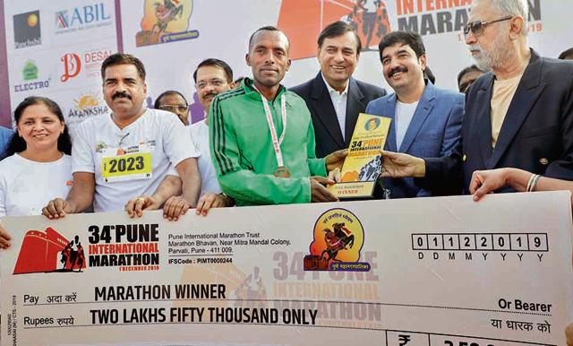 Dadi Solomon Teka of Ethiopia receives his winner’s cheque after finishing first at the Pune International Marathon on Sunday. (Rahul Raut/HT PHOTO)