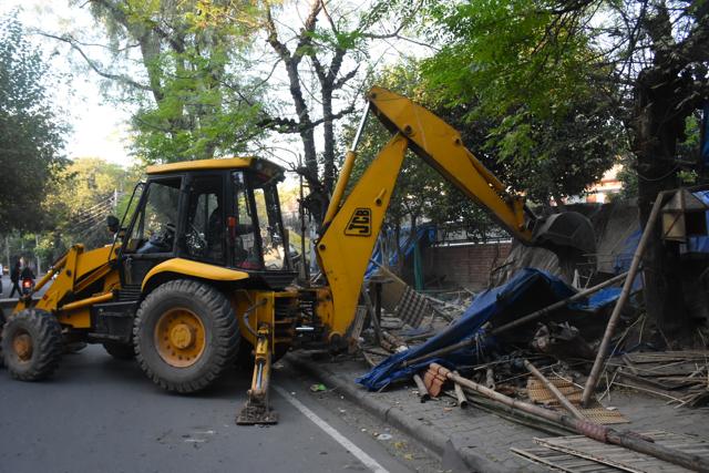An earthmoving machine razing temporary structures at the chick market in Sector 22, Chandigarh, on Friday. (HT PHOTO)