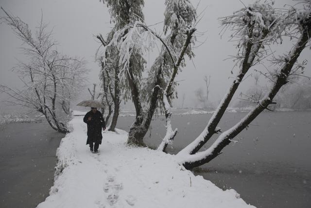 A Kashmiri man walks on a snow covered road as it snows in the interiors of Dal Lake in Srinagar, on Friday. (AP Photo) A Kashmiri man walks on a snow covered road as it snows in the interiors of Dal Lake in Srinagar, on Friday. (AP Photo)