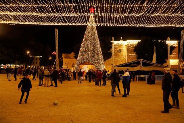 A girl plays with a ball as people stand at Manger Square in Bethlehem. (REUTERS) A girl plays with a ball as people stand at Manger Square in Bethlehem. (REUTERS)