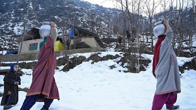 Women carrying water pitchers on their head after a water pipe got frozen due to sub zero temperatures on the outskirts of Srinagar. (AFP Photo) Women carrying water pitchers on their head after a water pipe got frozen due to sub zero temperatures on the outskirts of Srinagar. (AFP Photo)