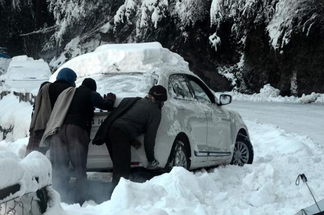 Commuters struggling to get their car moving in Shimla on Thursday. (Deepak Sansta/HT) Commuters struggling to get their car moving in Shimla on Thursday. (Deepak Sansta/HT)