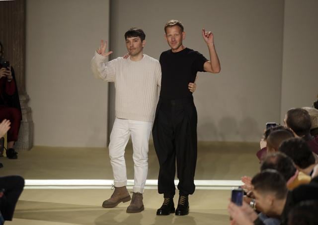 Creative director Paul Andrew, right, accept applause flanked by menswear designer Guillaume Meilland, at the conclusion of the the Salvatore Ferragamo men's Fall-Winter 2020/21 fashion show. (AP) Creative director Paul Andrew, right, accept applause flanked by menswear designer Guillaume Meilland, at the conclusion of the the Salvatore Ferragamo men's Fall-Winter 2020/21 fashion show. (AP)