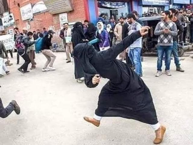 Image shows a burka-clad woman throwing stones. Image shows a burka-clad woman throwing stones.