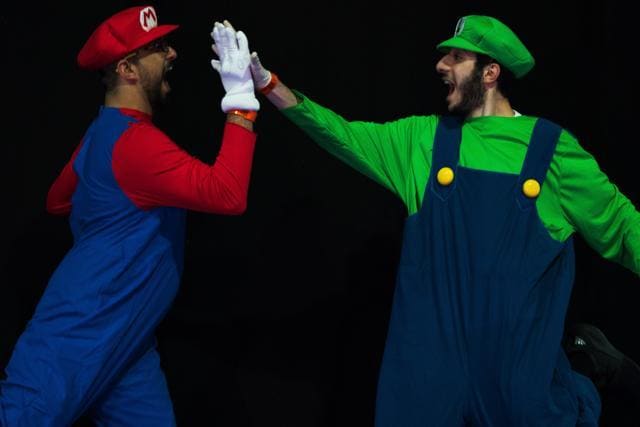 Bibi Zumot of Jordan, left, dressed as Mario, and Mohamed Rashed of Egypt, right, dressed as Luigi, high-five at the Middle East Film &amp; Comic Con in Dubai, United Arab Emirates, Thursday, March 5, 2020. The Middle East Film &amp; Comic Con began Thursday night in Dubai, a city of skyscrapers and nightclubs suddenly subdued by the outbreak of the new coronavirus across the region. (AP Photo/Jon Gambrell) (AP)