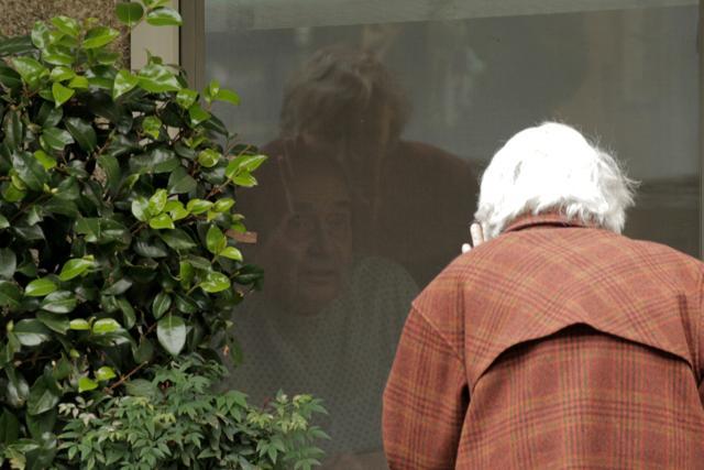 Dorothy Campbell waves while talking through a window to Gene Campbell. (REUTERS) Dorothy Campbell waves while talking through a window to Gene Campbell. (REUTERS)