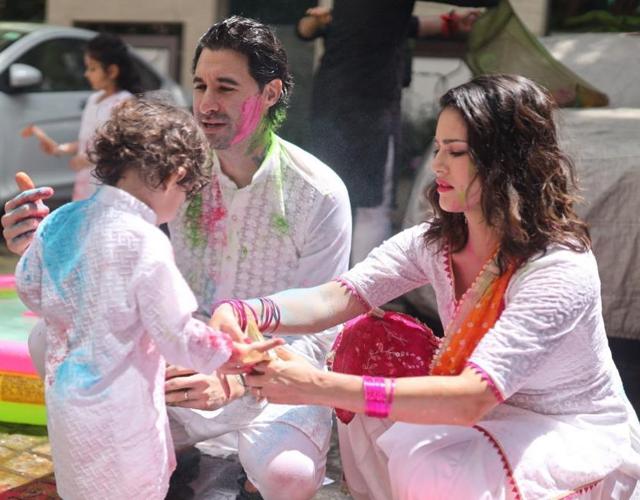 Sunny Leone helps out her son during Holi party. Sunny Leone helps out her son during Holi party.