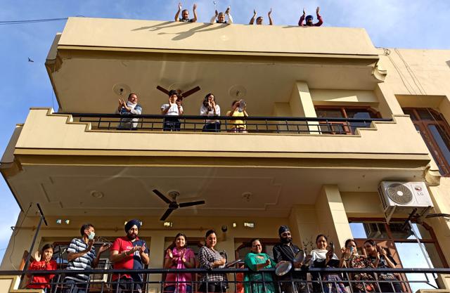 Residents of Sector 50 clapping and clanking plates in Chandigarh on Sunday. (Ravi Kumar/HT) Residents of Sector 50 clapping and clanking plates in Chandigarh on Sunday. (Ravi Kumar/HT)
