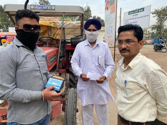 Mandi board officials checking a wheat sample for moisture content in Patiala on Wednesday. (HT Photo) Mandi board officials checking a wheat sample for moisture content in Patiala on Wednesday. (HT Photo)
