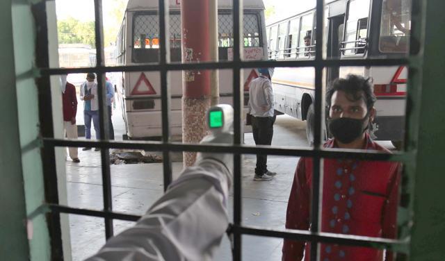 A passenger being thermally screened at the Ludhiana ISBT before being taken to the local railway station. (Gurpreet Singh/HT) A passenger being thermally screened at the Ludhiana ISBT before being taken to the local railway station. (Gurpreet Singh/HT)