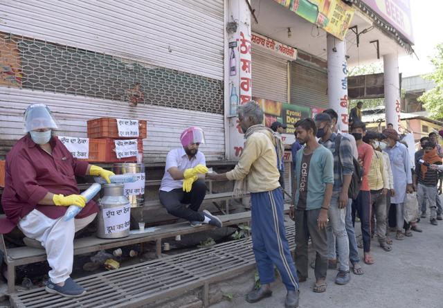 District president of Youth Akali Dal, Gurdeep Singh Gosha, distributing milk among people while protesting against government’s decision to reopen liquor vends in Ludhiana on Thursday. (Gurpreet Singh/HT)