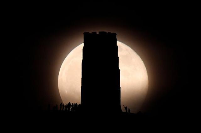 People are seen on Glastonbury Tor next to St Michaels Tower as the full moon, also known as the Supermoon or Flower Moon rises, Glastonbury, Britain, May 7, 2020. REUTERS/Toby Melville (REUTERS) People are seen on Glastonbury Tor next to St Michaels Tower as the full moon, also known as the Supermoon or Flower Moon rises, Glastonbury, Britain, May 7, 2020. REUTERS/Toby Melville (REUTERS)