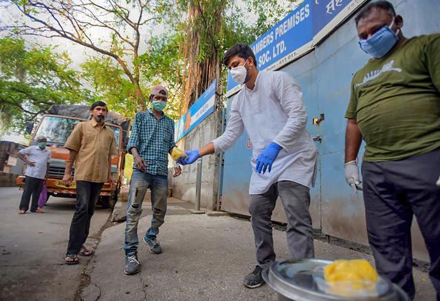 Akshay Kothawale, an auto-rickshaw driver distributes food among the needy from the money saved for his marriage ceremony. (PTI) Akshay Kothawale, an auto-rickshaw driver distributes food among the needy from the money saved for his marriage ceremony. (PTI)