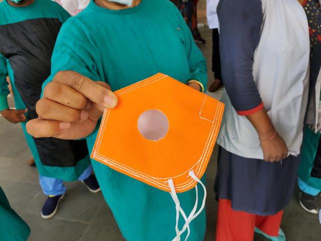 A health personnel holds up the masks being provided to frontline workers. (HT PHOTO ) A health personnel holds up the masks being provided to frontline workers. (HT PHOTO )