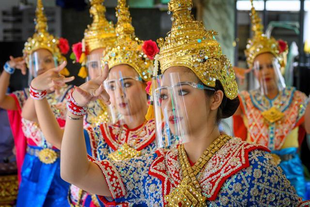 Traditional Thai dancers wear protective face shields and perform at the Erawan Shrine. (AFP) Traditional Thai dancers wear protective face shields and perform at the Erawan Shrine. (AFP)