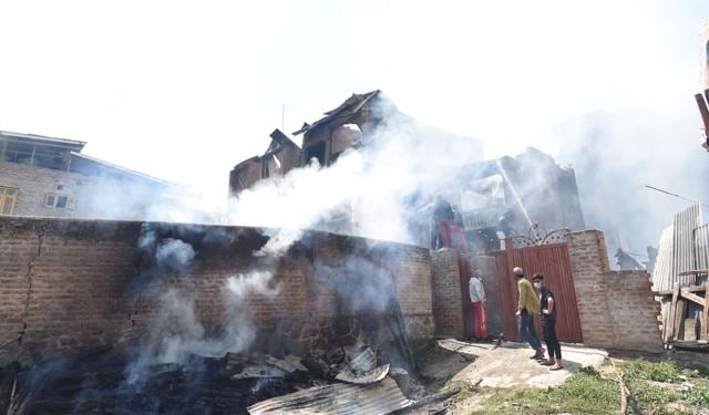 People inspecting the debris of a damaged house in Srinagar. (Waseem Andrabi / HT)
