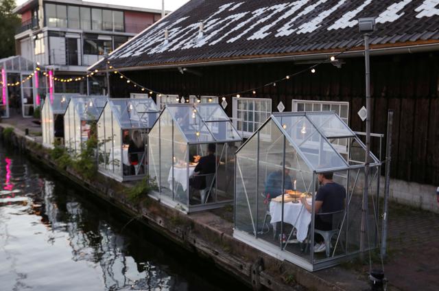A restaurant tests servers providing drinks and food to models pretending to be clients in a safe "quarantine greenhouses" in which guests can dine in Amsterdam, Netherlands. A restaurant tests servers providing drinks and food to models pretending to be clients in a safe "quarantine greenhouses" in which guests can dine in Amsterdam, Netherlands.