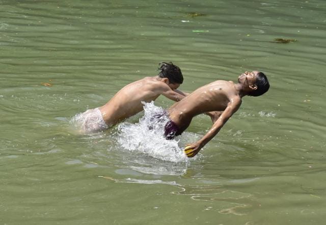Boys bathing in a canal to beat the heat at Tarn Taran Road, Amritsar, on Wednesday. (Sameer Sehgal/HT ) Boys bathing in a canal to beat the heat at Tarn Taran Road, Amritsar, on Wednesday. (Sameer Sehgal/HT )