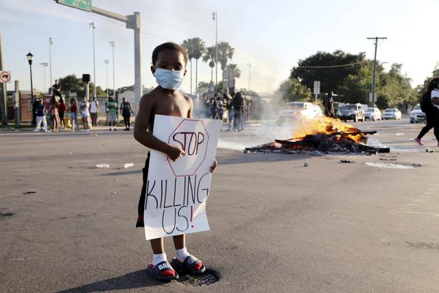 A five-year-old boy stands at an intersection where the road remained closed during a protest on Sunday, in Florida. (AP Photo) A five-year-old boy stands at an intersection where the road remained closed during a protest on Sunday, in Florida. (AP Photo)