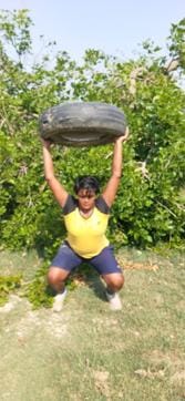Divya Shandily doing weight training while using a tyre in a field. (Special Arrangement) Divya Shandily doing weight training while using a tyre in a field. (Special Arrangement)